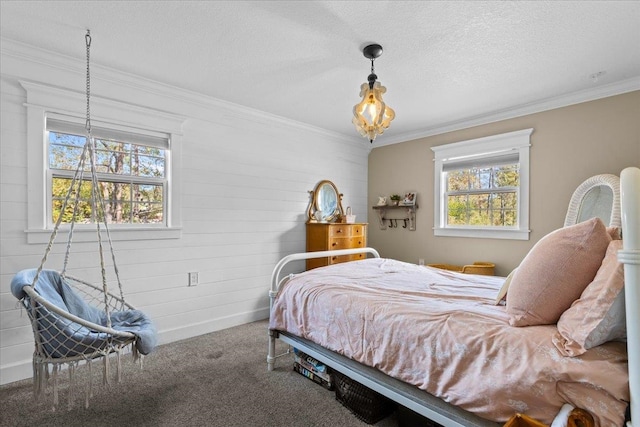 carpeted bedroom with a textured ceiling, multiple windows, and crown molding