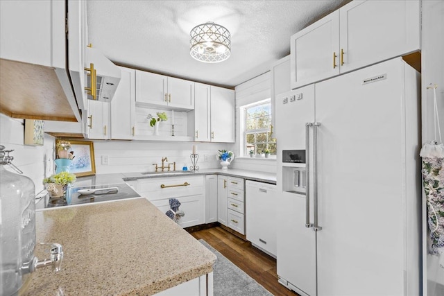 kitchen with white cabinets, white appliances, a textured ceiling, and light stone countertops