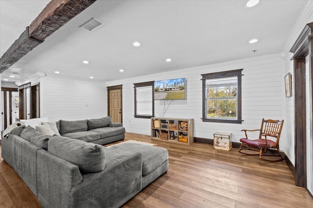 living room featuring wood walls, hardwood / wood-style flooring, and ornamental molding