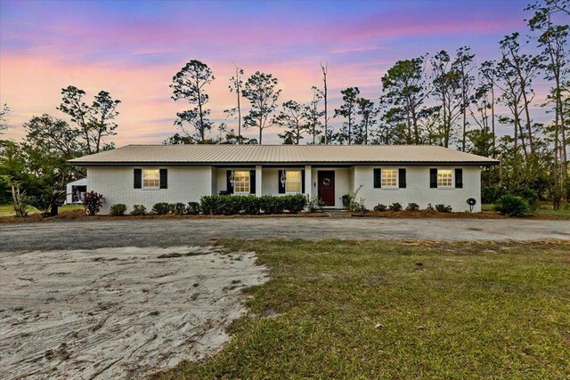 ranch-style home with a lawn