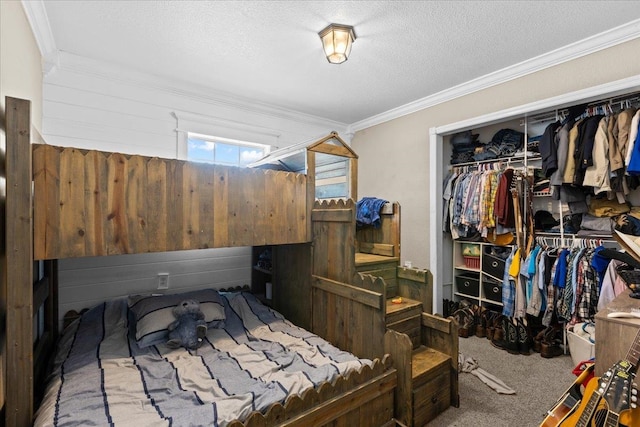 bedroom with a textured ceiling, carpet flooring, crown molding, wooden walls, and a closet