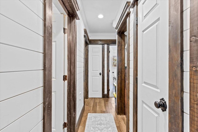 hallway featuring ornamental molding and light hardwood / wood-style floors