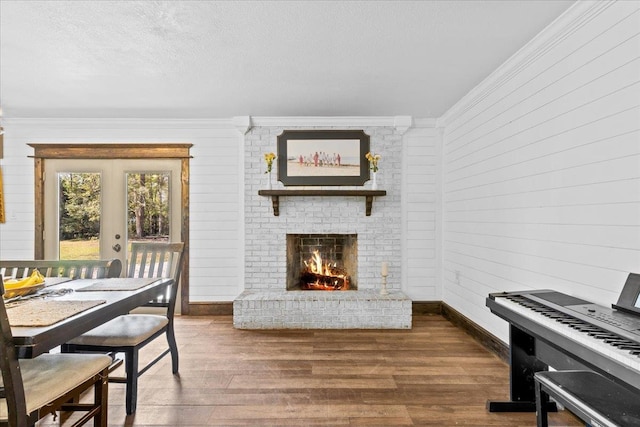 dining area featuring ornamental molding, wooden walls, dark hardwood / wood-style floors, and a fireplace