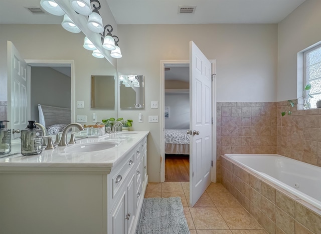 bathroom with vanity, tile patterned floors, and tiled tub