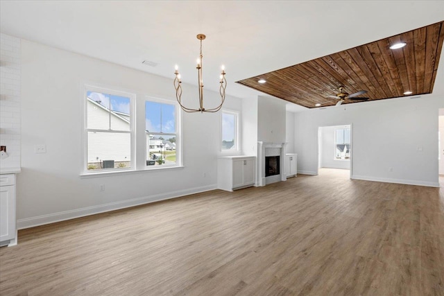 unfurnished living room with ceiling fan with notable chandelier, light hardwood / wood-style flooring, and wooden ceiling