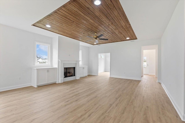 unfurnished living room with ceiling fan, wood ceiling, and light hardwood / wood-style flooring