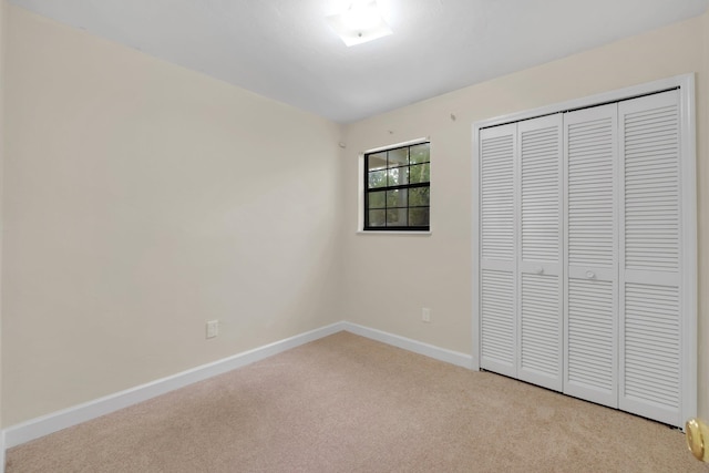 unfurnished bedroom with a closet and light carpet