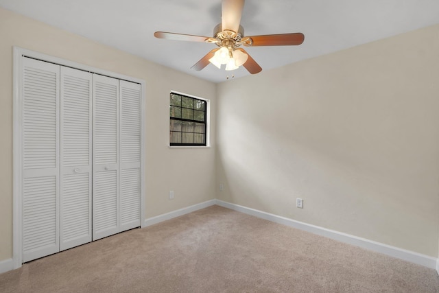 unfurnished bedroom featuring a closet, light colored carpet, and ceiling fan