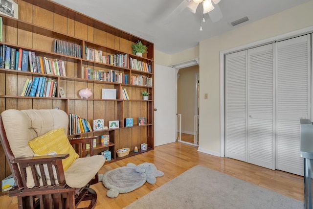 living area with light wood-type flooring and ceiling fan