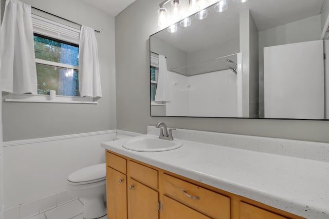 bathroom with vanity, tile patterned floors, toilet, and a shower