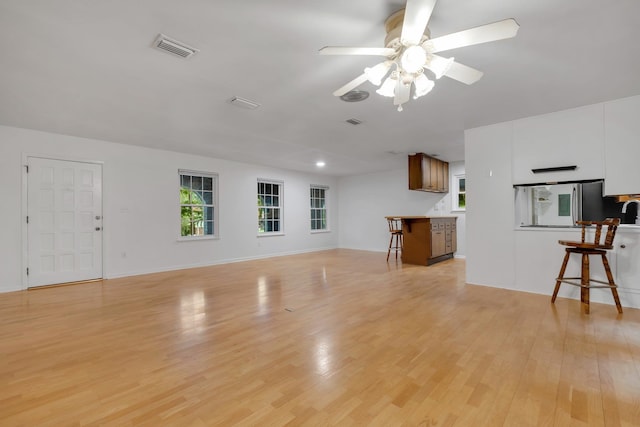 unfurnished living room featuring ceiling fan and light hardwood / wood-style flooring