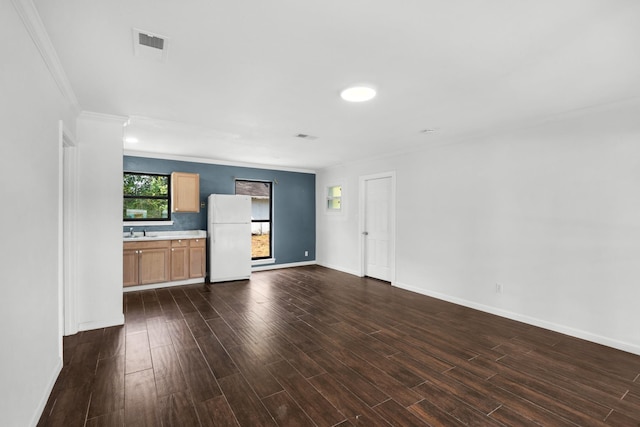 unfurnished living room with sink, crown molding, and dark hardwood / wood-style floors