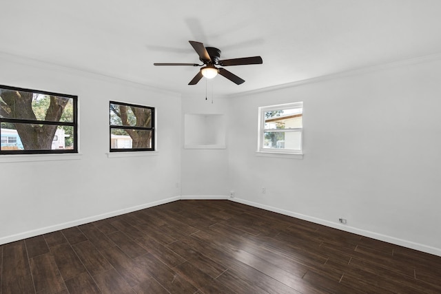 spare room featuring dark wood-type flooring, ceiling fan, and crown molding