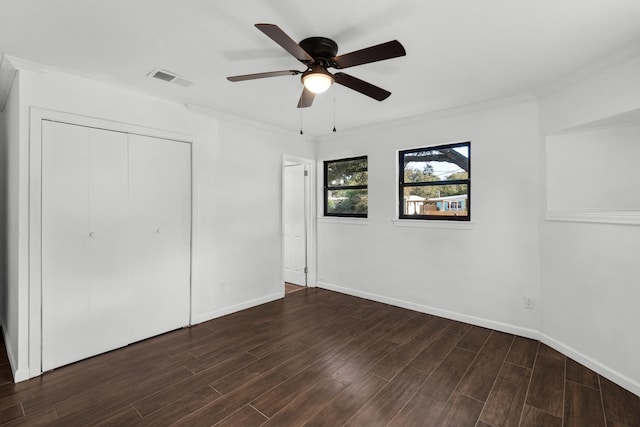 unfurnished bedroom featuring dark hardwood / wood-style flooring, crown molding, a closet, and ceiling fan