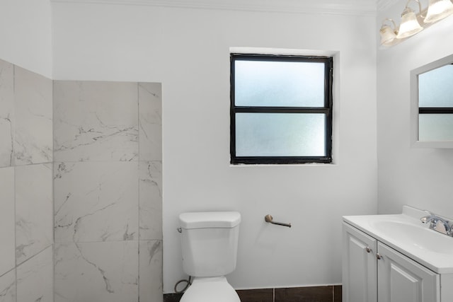 bathroom with vanity, crown molding, and toilet