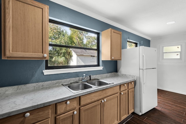 kitchen featuring sink, light stone counters, white refrigerator, ornamental molding, and dark hardwood / wood-style flooring