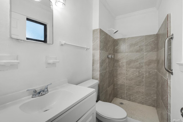 bathroom featuring ornamental molding, tiled shower, vanity, and toilet