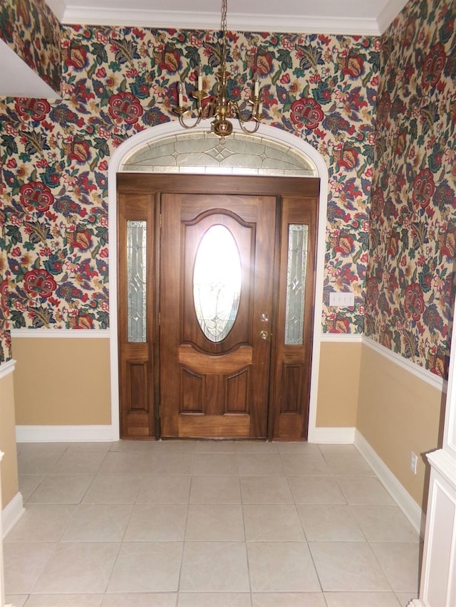 entryway with light tile patterned floors and crown molding