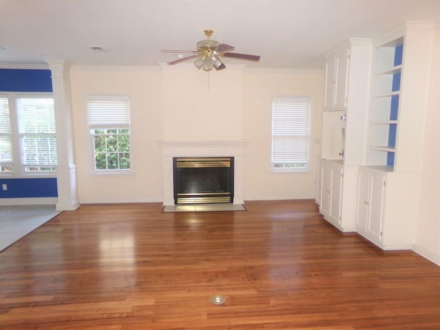 unfurnished living room featuring ceiling fan, dark wood-type flooring, and ornamental molding