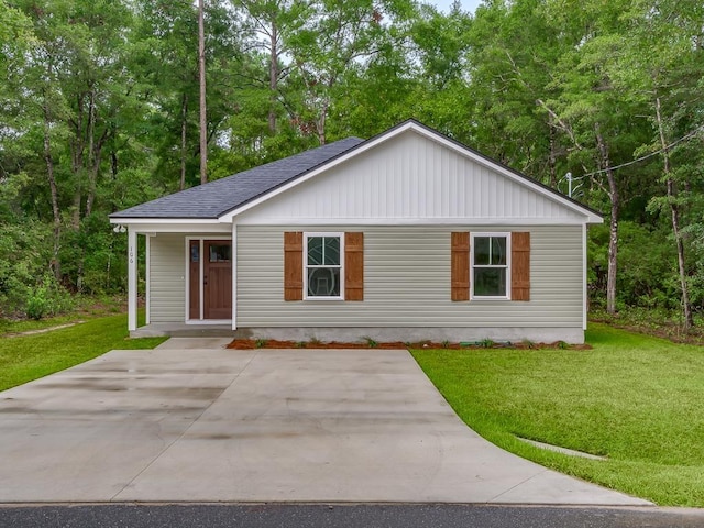single story home with roof with shingles and a front lawn