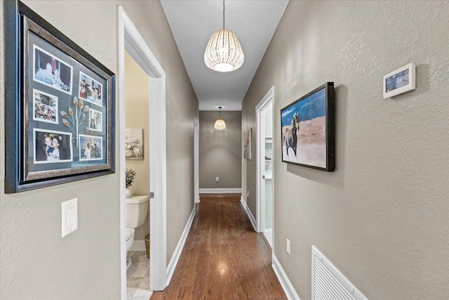 7087 Valhalla Ranch Dr, Perry, FL 32348 - corridor with a chandelier, a textured wall, and wood finished floors