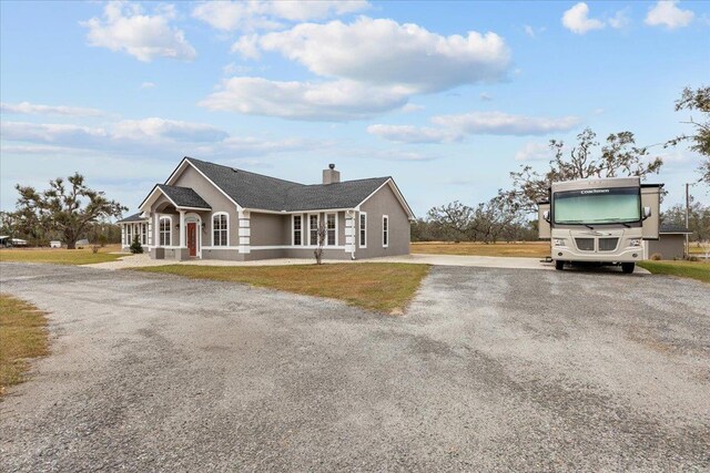 7087 Valhalla Ranch Dr, Perry, FL 32348 - view of front of property with gravel driveway, a chimney, and stucco siding