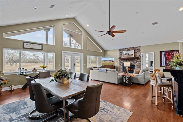 7087 Valhalla Ranch Dr, Perry, FL 32348 - dining room with a stone fireplace, high vaulted ceiling, wood finished floors, a ceiling fan, and french doors