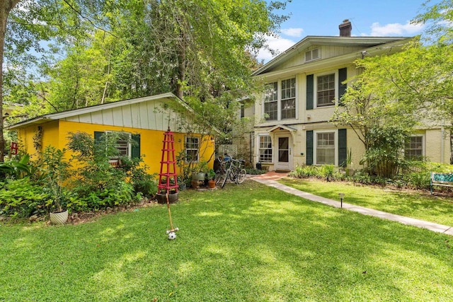 view of front of home featuring a front lawn and a chimney