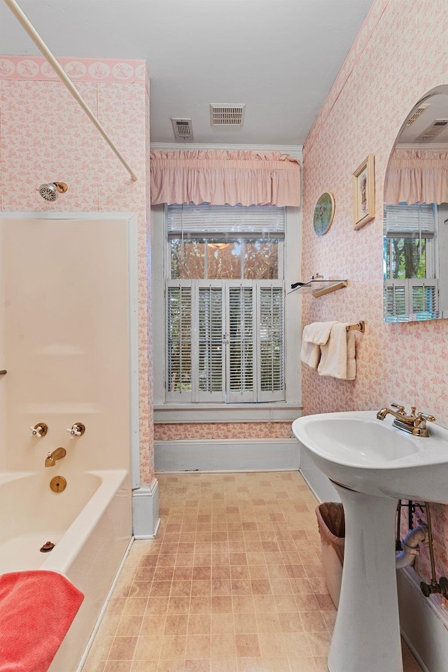 bathroom featuring bathing tub / shower combination, visible vents, and wallpapered walls