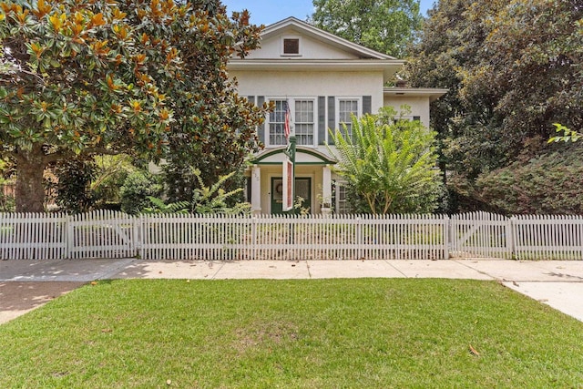 view of front of house featuring a front lawn, a fenced front yard, and stucco siding