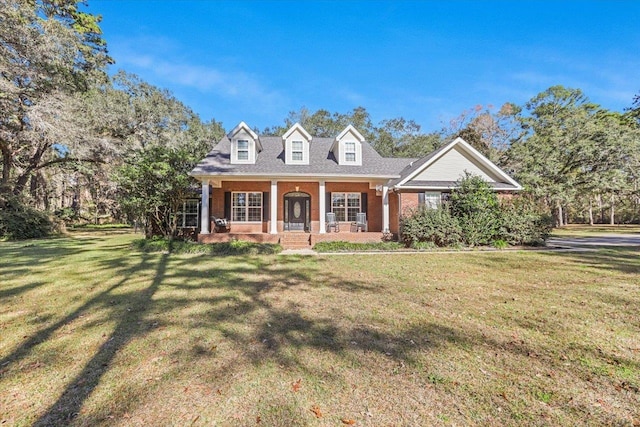 new england style home featuring a porch and a front yard