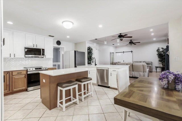 kitchen with white cabinets, a kitchen island, and appliances with stainless steel finishes