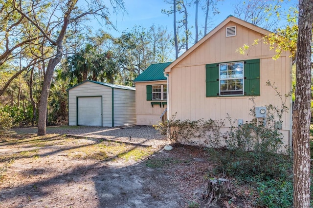 view of property exterior featuring a garage and an outdoor structure