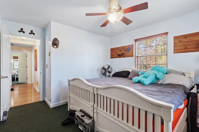 bedroom featuring dark carpet and ceiling fan