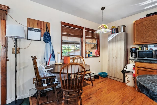 dining room with a baseboard heating unit and light hardwood / wood-style flooring