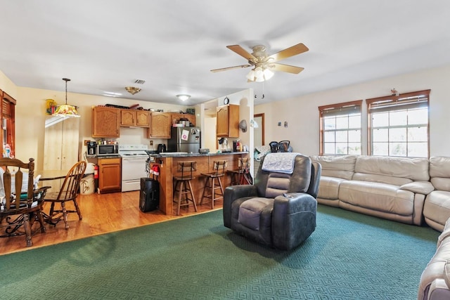 living room with ceiling fan and light hardwood / wood-style floors