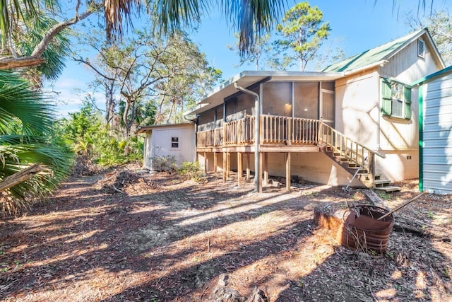 rear view of house featuring a sunroom