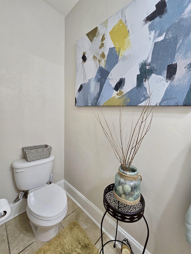 bathroom with baseboards, toilet, and tile patterned floors