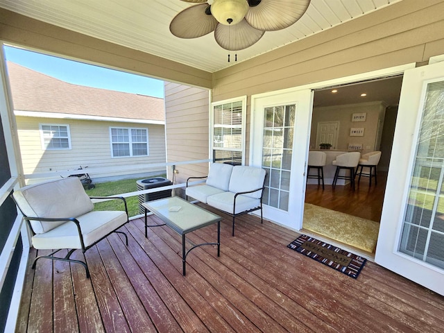 wooden deck featuring an outdoor hangout area and a ceiling fan
