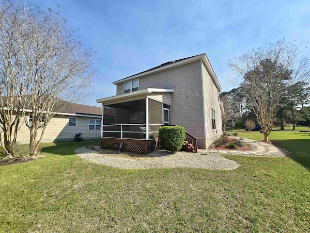 back of property featuring a lawn and a sunroom