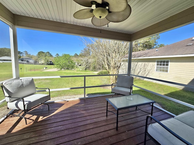 wooden deck featuring a lawn and ceiling fan