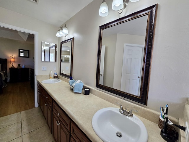 ensuite bathroom with tile patterned flooring, a sink, double vanity, and connected bathroom