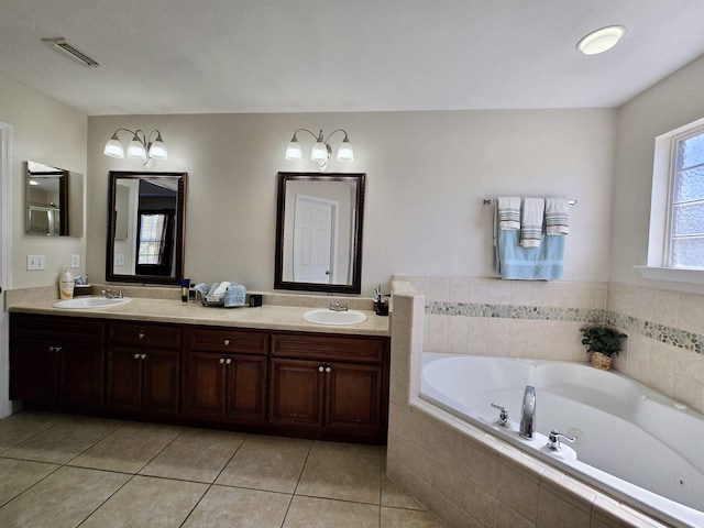 bathroom with a bath, visible vents, a sink, and tile patterned floors