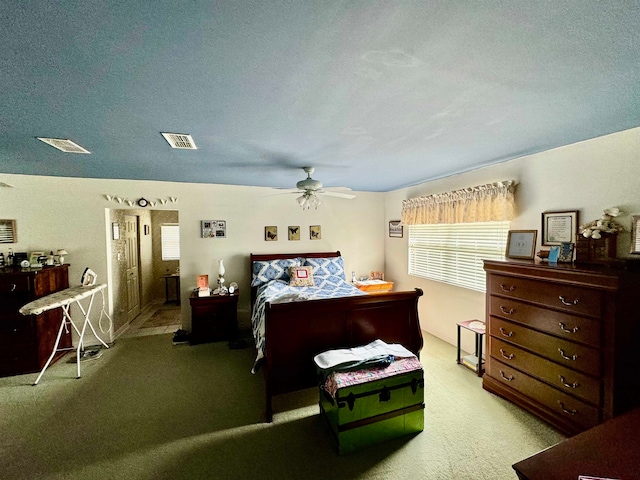 carpeted bedroom with ceiling fan and a textured ceiling