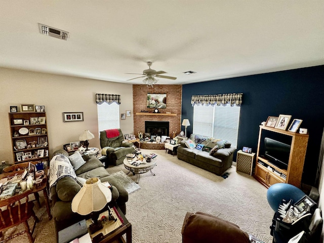 carpeted living room featuring a fireplace and ceiling fan