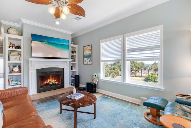 1548 Shell Point Rd, Crawfordville, FL 32327 - living area with wood finished floors, ceiling fan, ornamental molding, a warm lit fireplace, and baseboards