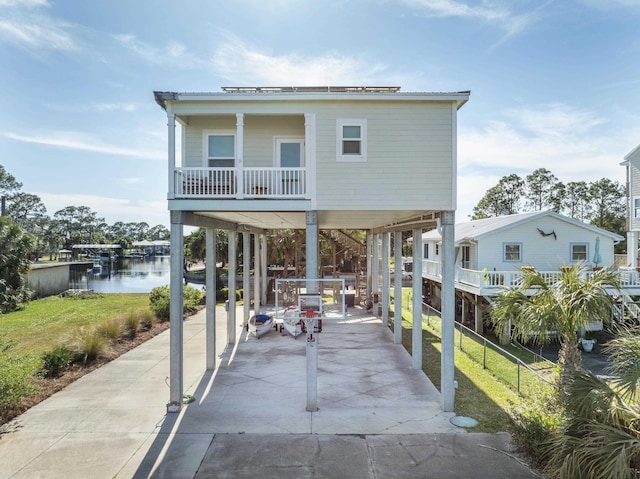 1548 Shell Point Rd, Crawfordville, FL 32327 - view of front of property with a carport, concrete driveway, and a water view