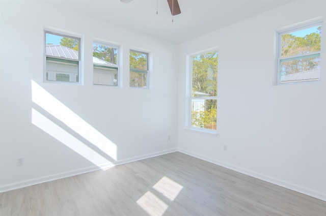 spare room featuring ceiling fan, light hardwood / wood-style floors, and a wealth of natural light