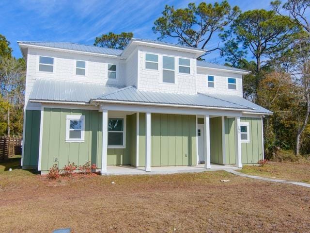 back of property with a yard and covered porch