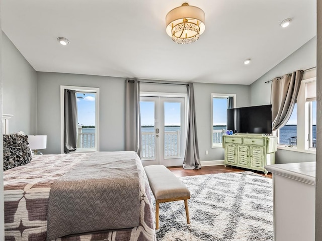 bedroom featuring french doors, hardwood / wood-style floors, multiple windows, and vaulted ceiling